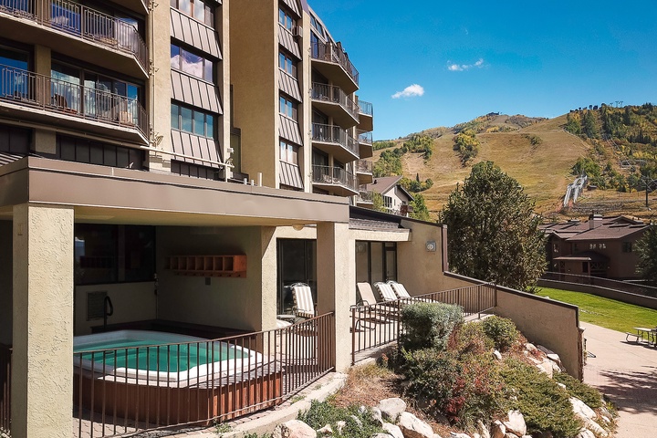 Multi-level building nestled in a mountain valley, offering easy access to alpine slopes and scenic hillside views from private balconies.