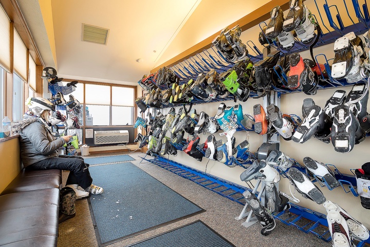 A well-stocked ski and snowboard rental room awaits your adventure on the slopes, with gear for all skill levels neatly organized.