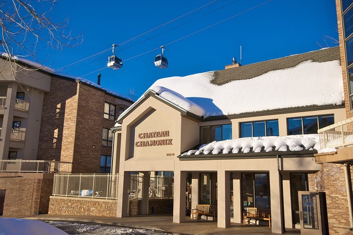 Chateau Chamonix entrance welcomes guests to a premier ski-in location beneath the iconic gondola, surrounded by mountain village charm and fresh alpine snow.