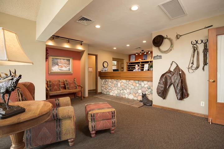 The lodge's reception area welcomes guests with warm Western charm, featuring authentic ranch décor, cozy seating, and rustic stonework that sets the tone for your mountain getaway.