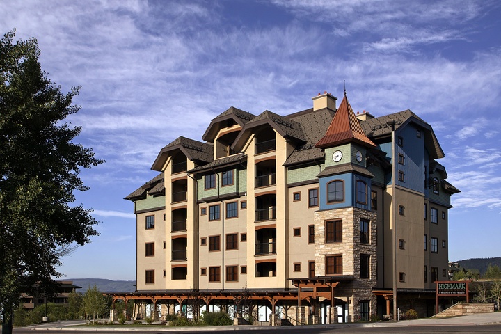 A distinctive alpine-style vacation property with a charming turret and mountain-resort architecture, located in a scenic area with forested hills visible in the distance.