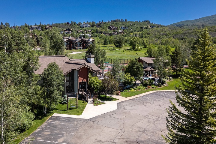 Nestled in a mountain community, the property offers ample parking, lush green surroundings, and easy access to nearby amenities and recreational areas.