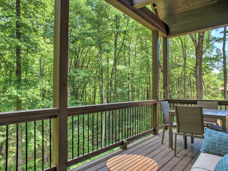 Covered Deck with Seating and Wooded Surroundings
