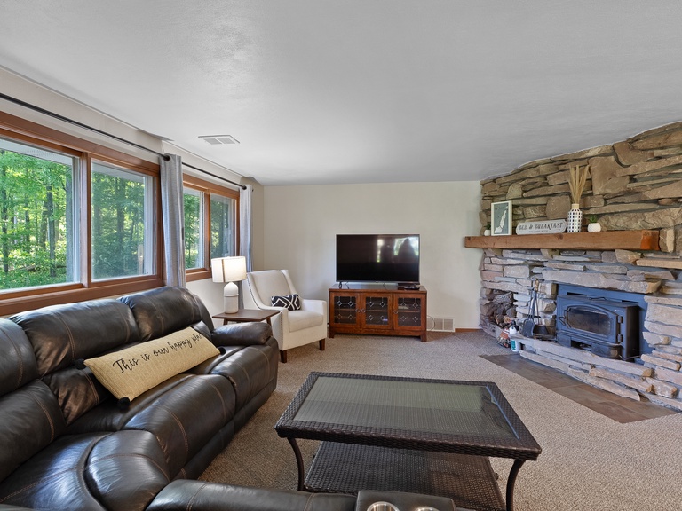 Main living space includes comfortable seating, Smart TV and wood burning stove