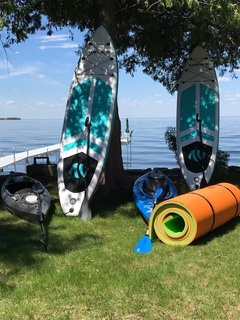 Two paddle boards, two kayaks, and a floating waterpad