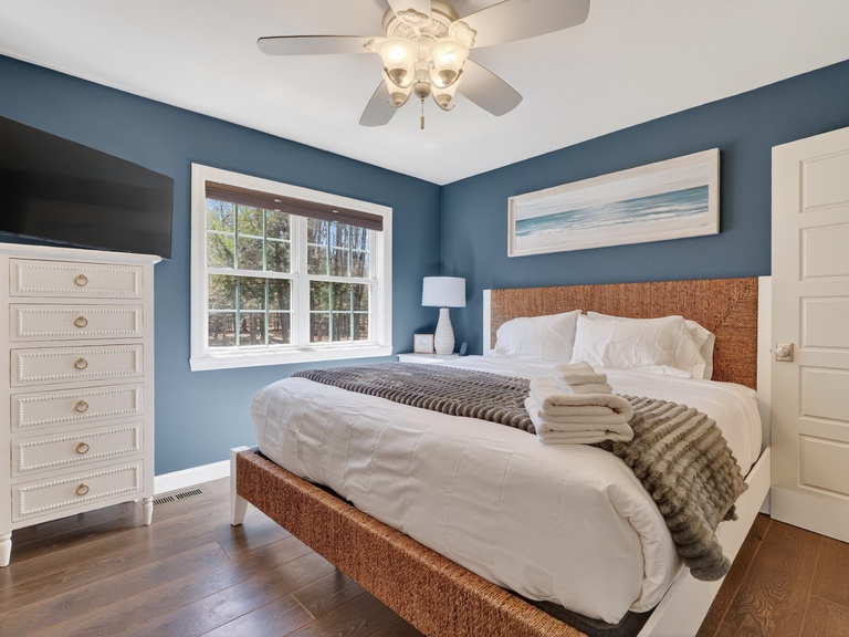 Relax in this tranquil King bed with soothing blue walls, crisp white linens, and coastal artwork that invites peaceful dreams.