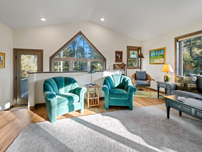 Living room area includes multiple seating areas and a Smart TV