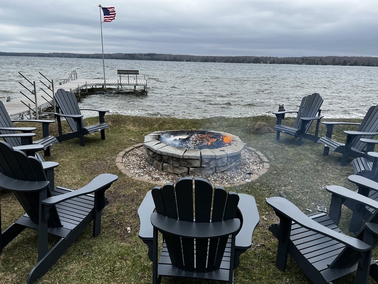 The shared lakefront includes a seasonally installed dock, fire pit, chairs and sunset views