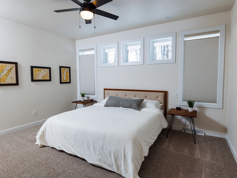 King size bed and ceiling fan in main bedroom on the main level