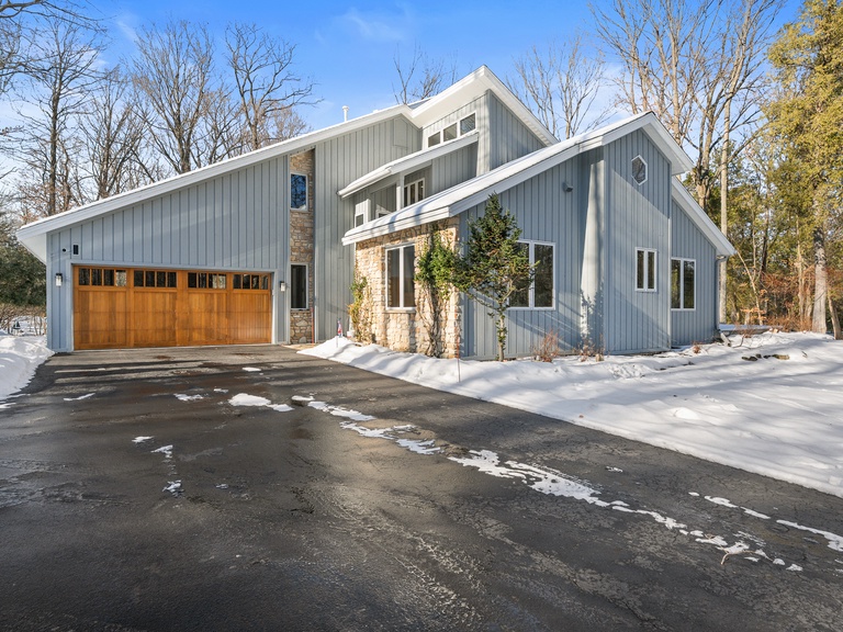Modern architectural design meets natural woodland setting in this striking winter retreat with convenient parking access.