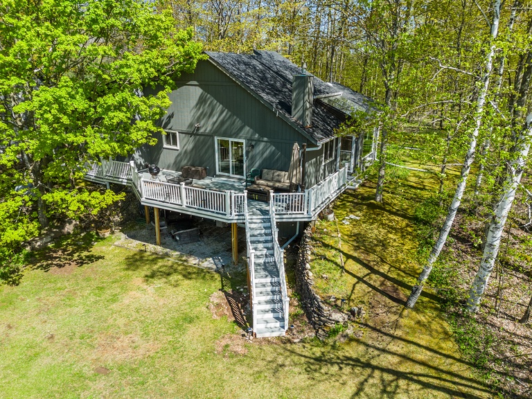 Highlights include a wrap around deck and private wooded lot