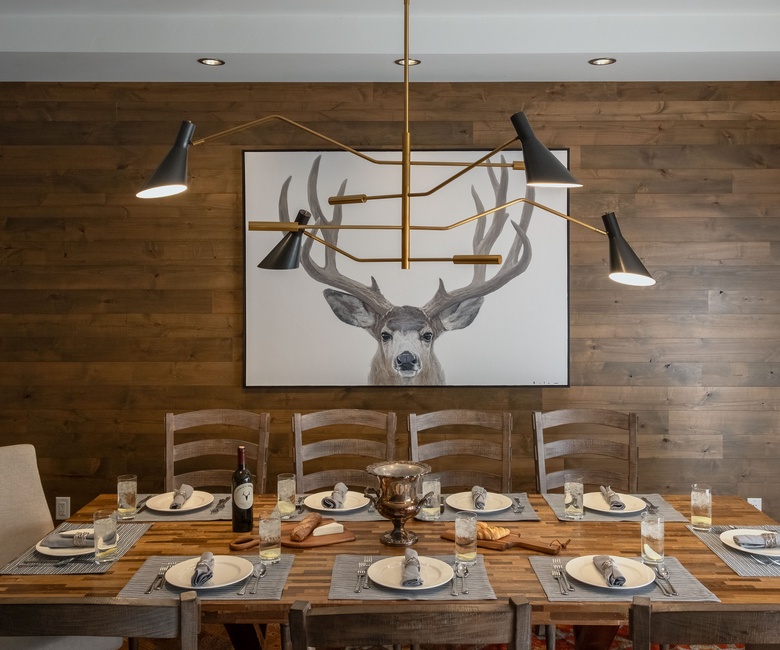 Dining Area, Main Level - Dining table beneath modern chandelier and wood accent wall