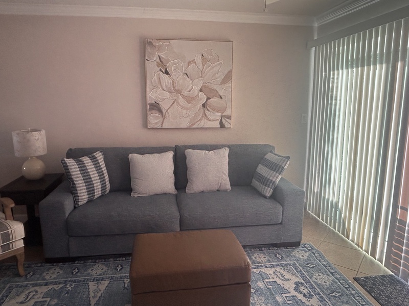 Sink into your comfortable gray sofa surrounded by soft neutral tones and gentle artwork, creating the perfect space to unwind after your adventures.