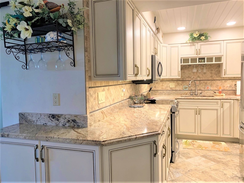 You'll love preparing meals in this elegant kitchen featuring granite countertops, classic white cabinetry, and upscale touches throughout.