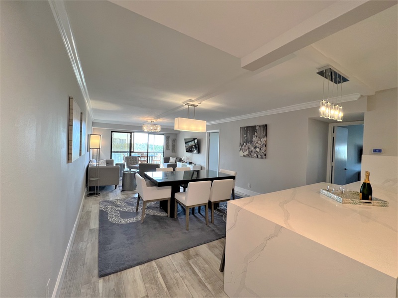 Relax in your elegant open-plan living space with sparkling chandeliers, marble countertops, and stunning views through floor-to-ceiling windows.