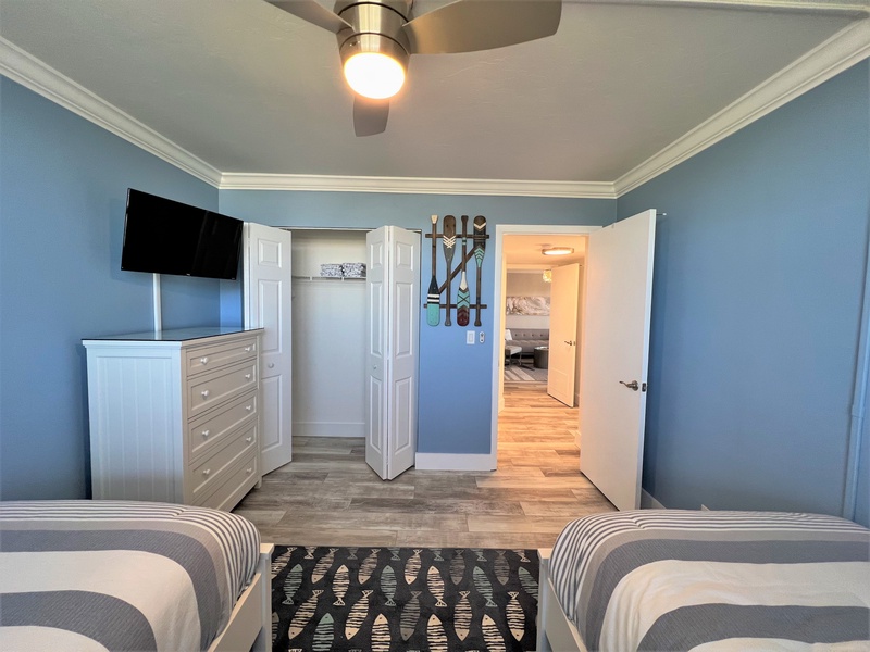 Your coastal-themed bedroom features twin beds, smart TV, and organized closet space for a relaxing oceanside retreat.