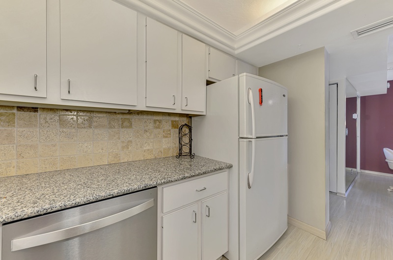 Your fully equipped kitchen features granite countertops, crisp white cabinetry, and stainless steel appliances—perfect for preparing meals during your stay.