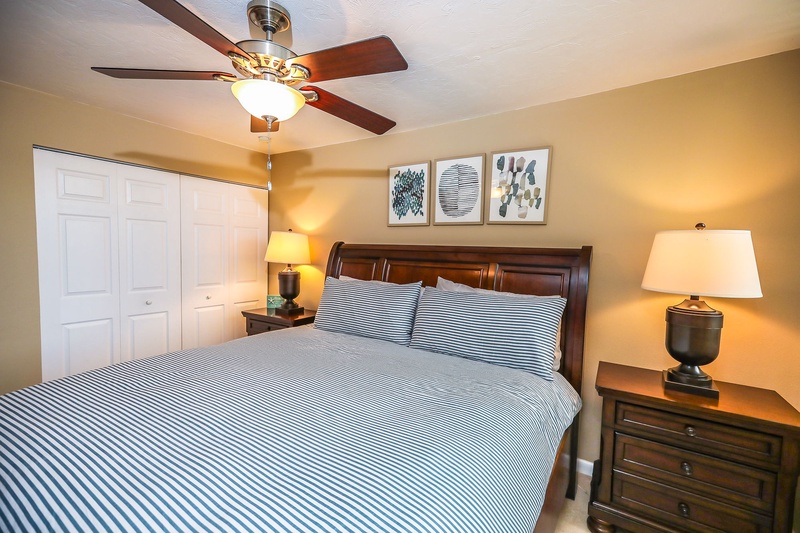 Your bedroom sanctuary features a plush bed with crisp linens, gentle ceiling fan, and warm bedside lighting for restful nights.