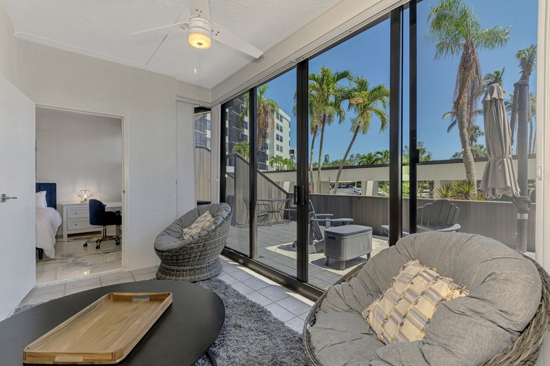 Relax in your modern living space with floor-to-ceiling windows opening to your private balcony with hot tub and tropical palm tree views.
