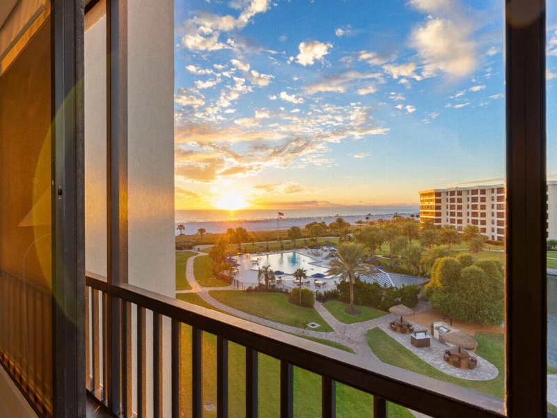 Stunning sunset views from your private balcony showcase the resort's pool and lush grounds in golden hour light.