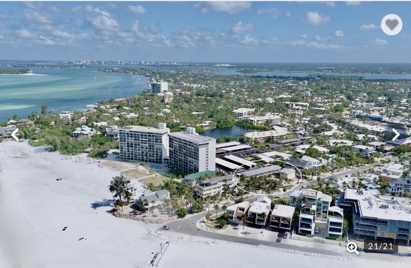 Stunning aerial view of the beachfront property and surrounding coastal community with pristine white sand beaches and turquoise waters.