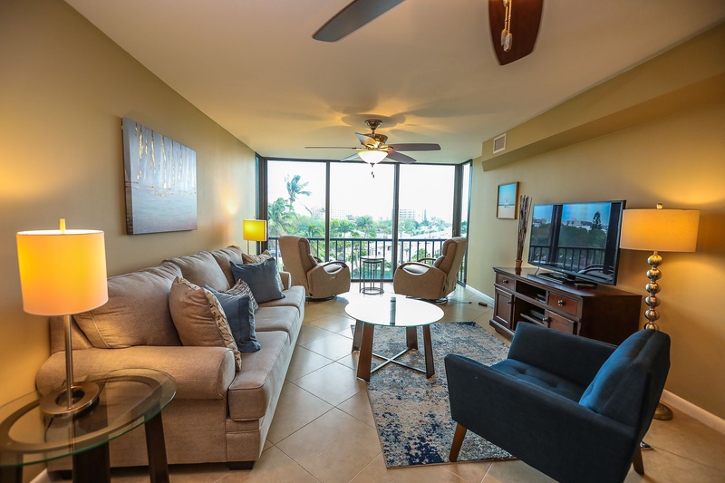 Relax in your stylish living room with plush seating, warm lighting, and tropical views from your private balcony.