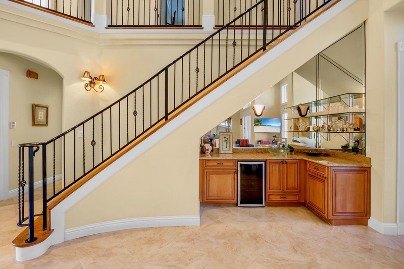 Elegant wet bar beneath the grand staircase