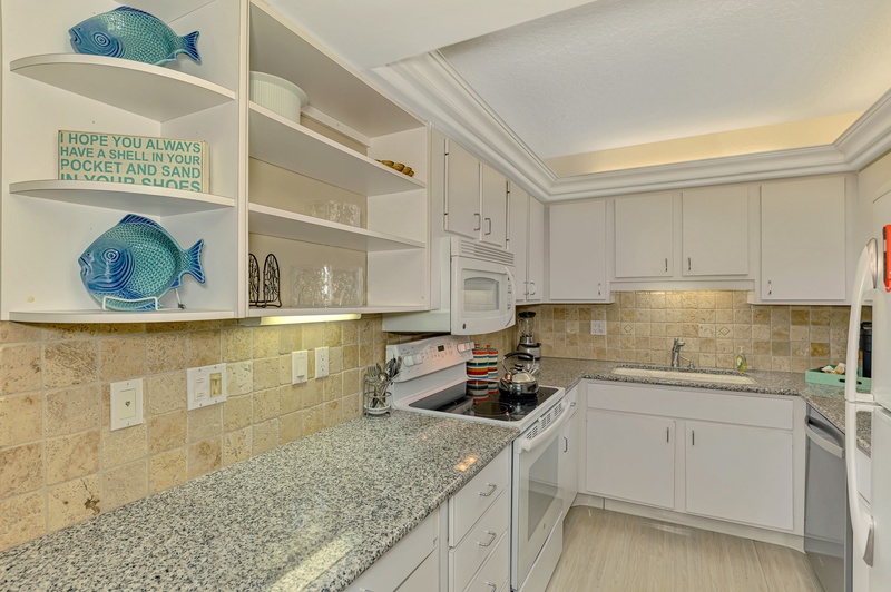 Your fully equipped kitchen features granite counters, coastal décor, and everything you need to prepare delicious meals during your stay.