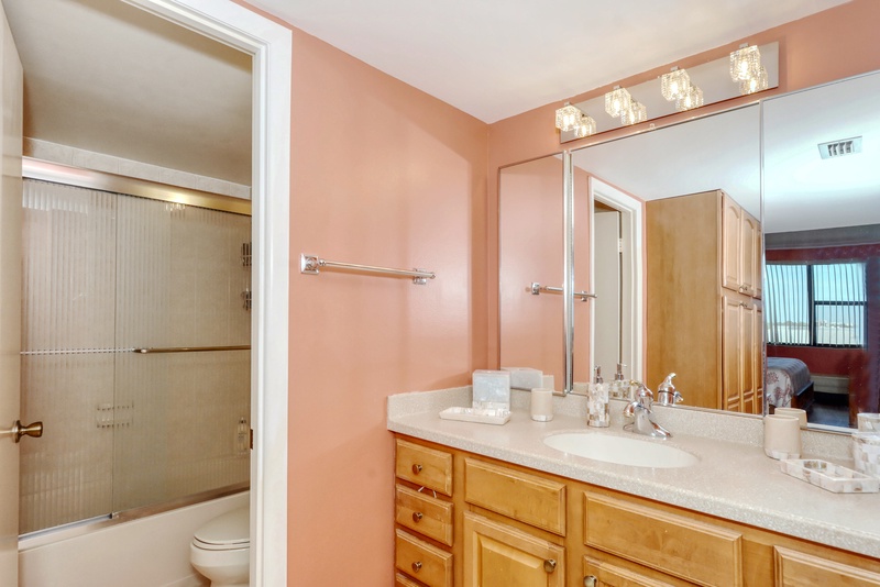 Freshen up in your spacious bathroom featuring a glass shower, modern vanity, and warm lighting that makes every morning feel special.