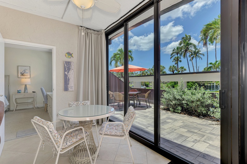 Your bright dining area flows seamlessly to your private patio, where swaying palms frame tropical views beyond.