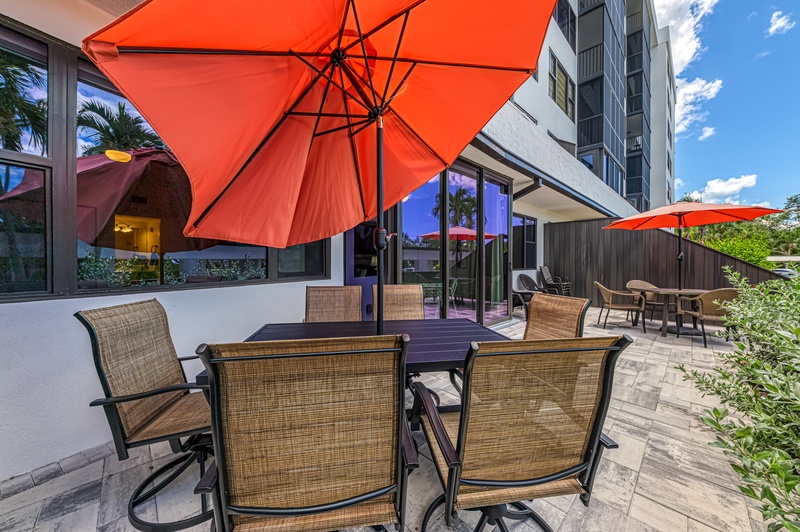 Enjoy al fresco dining on your private patio with comfortable seating and vibrant umbrellas for perfect shade.