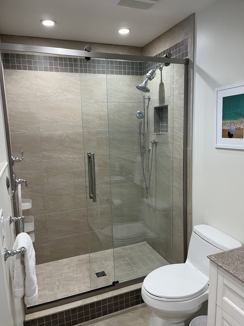 Your spa-style bathroom features a stunning walk-in shower with rainfall head and sleek glass doors, perfect for unwinding after beach days.