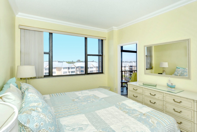 Wake up in this sunny bedroom where soft coastal colors and your private balcony create the perfect seaside retreat.