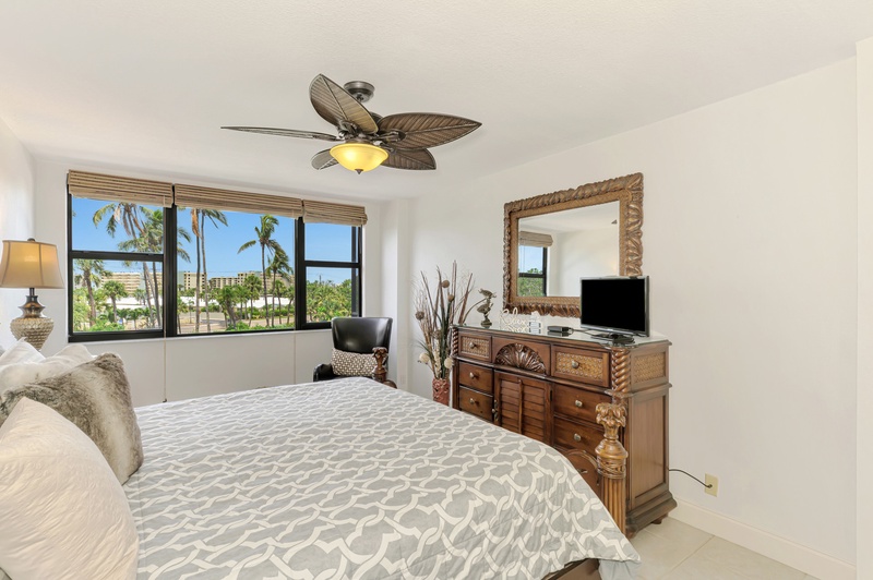Wake up to tropical palm views in your peaceful bedroom, complete with elegant furnishings and cooling ceiling fan.