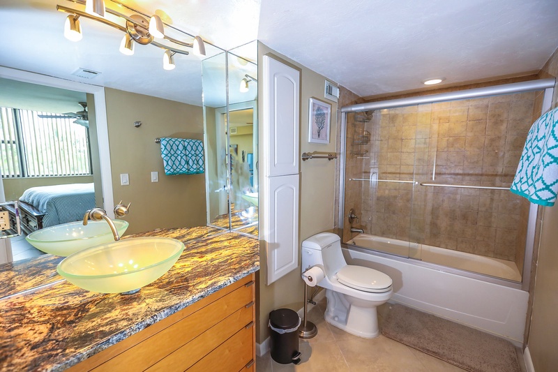 Unwind in your spa-like bathroom featuring a stunning granite vanity, vessel sink, and spacious tub-shower combo with elegant tile work.