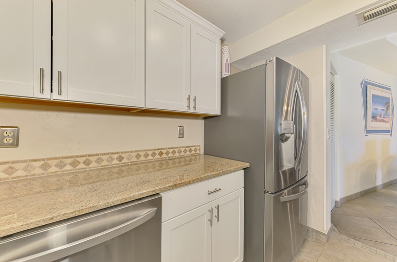 Your fully equipped kitchen features granite counters, stainless appliances, and crisp white cabinetry for effortless meal preparation.