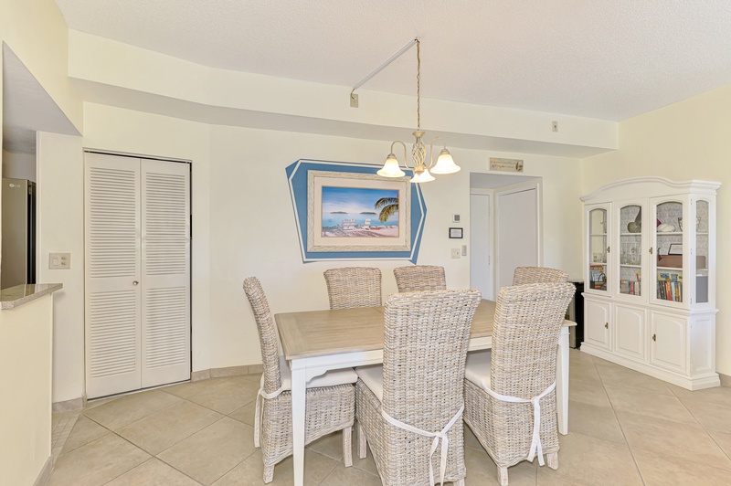 Your bright dining space features coastal charm with wicker chairs and tropical artwork, perfect for memorable meals together.