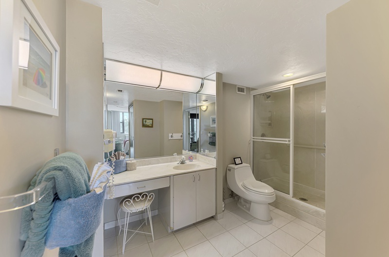 Your spacious bathroom features a glass-enclosed shower, vanity with mirror, and everything needed for a refreshing start to your day.