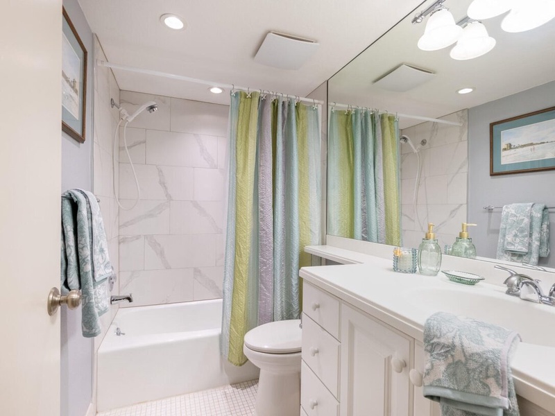Unwind in your pristine bathroom featuring marble-style tiling and spa-inspired touches that create a serene retreat.