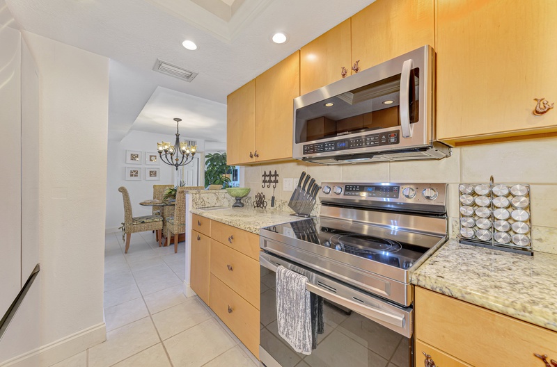 Your fully equipped kitchen features granite counters, stainless appliances, and flows into the bright dining area.