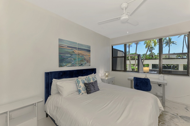 Drift off in your serene bedroom with tropical palm views and ocean-inspired art creating the perfect coastal retreat.