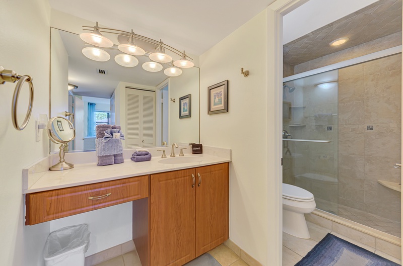 Your elegant ensuite features premium finishes, perfect vanity lighting for your morning routine, and a luxurious glass-enclosed shower.