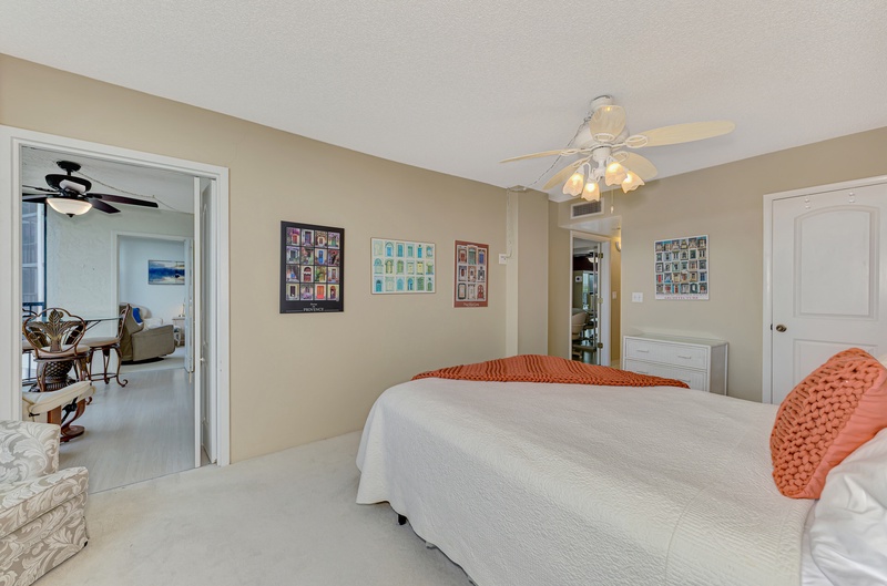 Your peaceful bedroom awaits with colorful art collections, soft linens, and a gentle ceiling fan for comfort.