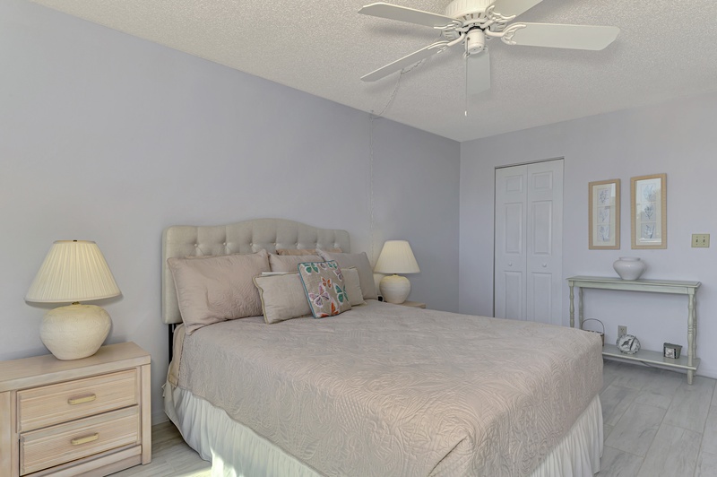 Rest peacefully in your serene bedroom featuring soft neutral tones, elegant furnishings, and gentle ceiling fan breezes.