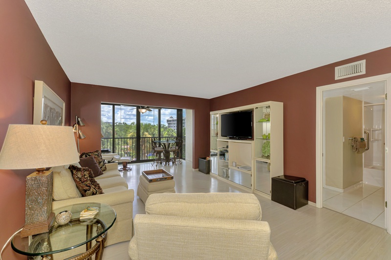 Relax in your spacious living area with comfortable seating, entertainment center, and scenic balcony views for perfect vacation moments.