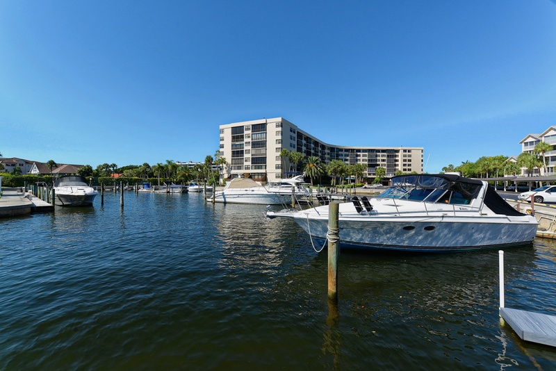 Waterfront property located on a peaceful marina with boats and tropical surroundings in a resort-style community.