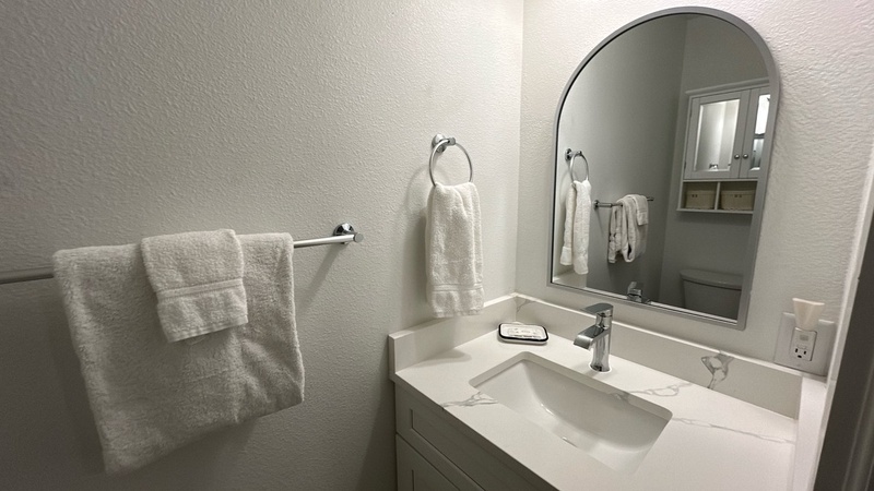 Step into your private bathroom retreat with plush towels, elegant marble countertops, and thoughtful amenities awaiting your arrival.