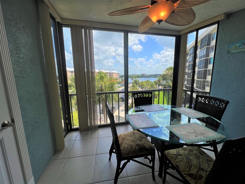 Enjoy morning coffee at your private dining table with stunning water views through floor-to-ceiling windows.