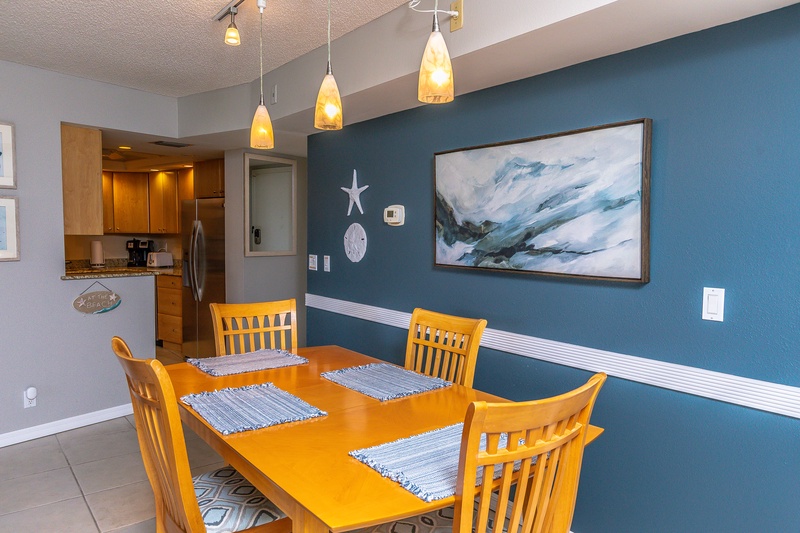 Your bright dining space features coastal artwork and warm lighting, perfect for enjoying meals with ocean-inspired ambiance throughout your stay.