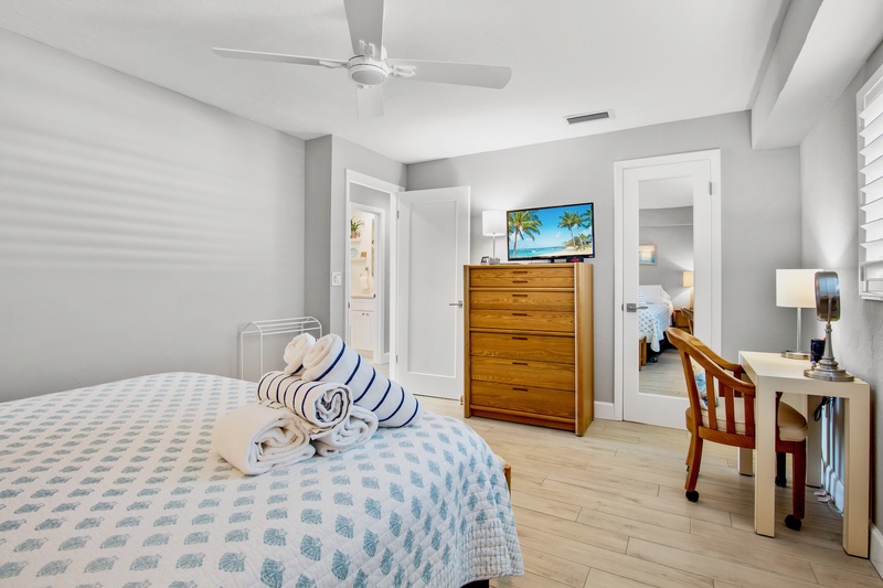 Unwind in your serene bedroom featuring coastal-chic decor, ceiling fan comfort, and entertainment on demand.